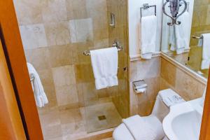 a bathroom with a shower with a toilet and a sink at Crown Regency Prince Resort in Boracay