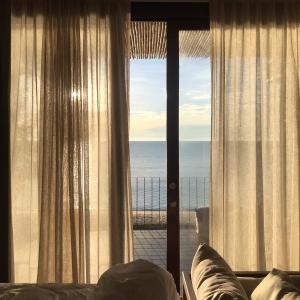 a bedroom with a window with a view of the ocean at Chula Beach Resort in Khanom