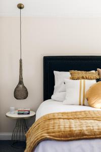 a bedroom with a bed with a black headboard and a table at Luxury on Loch in Beechworth