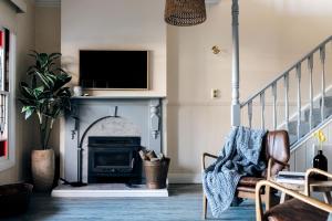 a living room with a fireplace and a tv at Luxury on Loch in Beechworth