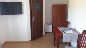 a room with a table and a television and a room with a table at Malinowe Lato in Grzybowo