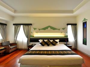 a bedroom with a large bed and a couch at Amazing Inlay Resort in Nyaungshwe Township
