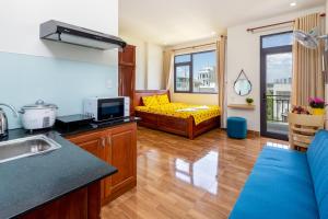 a kitchen and living room with a yellow couch at Loving Homestay & Apartment Da Nang in Danang