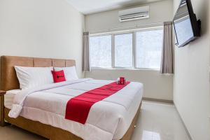 a bedroom with a large bed and a television at RedDoorz near Ciputra World 3 in Surabaya