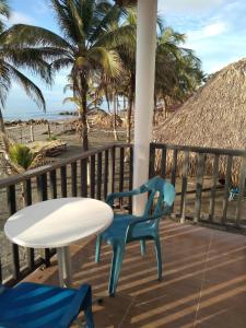 uma mesa e cadeiras num deque com praia em Tadù Playa Hotel em San Bernardo del Viento