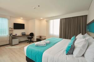a bedroom with a bed and a desk with a computer at Hotel Nivari Duitama in Duitama +39 photos