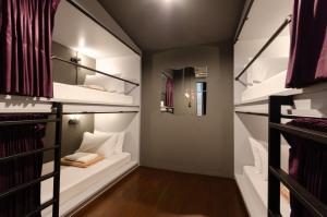 um quarto com 3 beliches e um corredor em Tian Tian Hostel em Bangkok