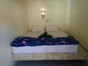 a bed with a stuffed animal sitting on top of it at Backpackers Home Amed in Amed