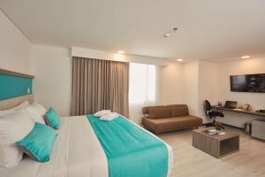 a hotel room with a bed and a couch at Hotel Nivari Duitama in Duitama