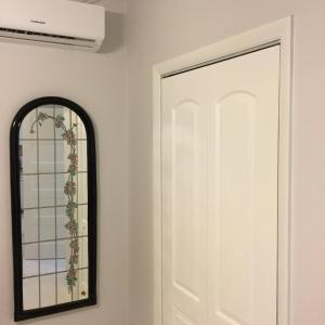 a mirror next to a white door in a room at Courage in Nassau