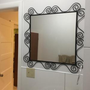 espejo colgado en la pared del baño en Courage en Nassau