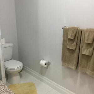 uma casa de banho com WC e toalhas na parede em Courage em Nassau