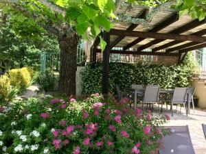 um jardim com mesa, cadeiras e flores em Les Feuillantines Perigord Noir em Saint-Cyprien