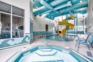 a swimming pool with a slide in a building at Comfort Inn & Suites South in Calgary