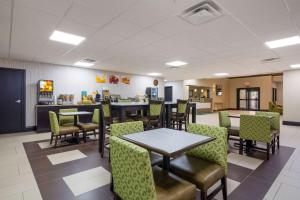 a restaurant with tables and chairs and a counter at Quality Inn & Suites in Sellersburg