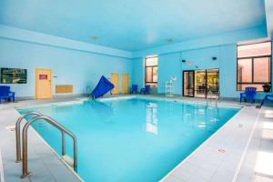 een groot zwembad in een gebouw met blauwe muren bij Quality Inn & Suites-Sellersburg in Sellersburg