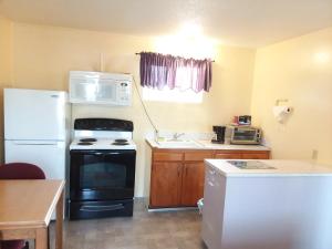 a kitchen with a white refrigerator and a microwave at Shiny Motel in Hoquiam