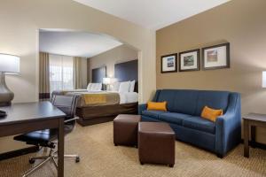 a hotel room with a bed and a blue couch at Comfort Inn & Suites North Little Rock McCain Mall in North Little Rock