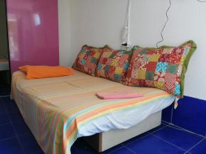 een bed met kleurrijke lakens en kussens in een kamer bij Aleksandar in Sutomore