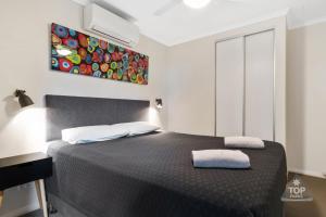 a bedroom with a bed and a lamp at Jurien Bay Tourist Park in Jurien Bay