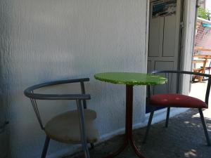 een tafel en twee stoelen en een groene tafel en stoelen bij Aleksandar in Sutomore