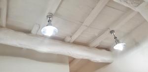 duas luzes penduradas no tecto de um quarto em La Casa di Alberto em Bolsena