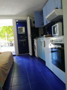 een keuken met een blauwe tegelvloer in een kamer bij Aleksandar in Sutomore