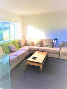ein Wohnzimmer mit einem Sofa und einem Couchtisch in der Unterkunft Sylvia Park House in Auckland