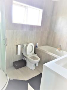 a bathroom with a toilet and a bath tub at Sylvia Park House in Auckland