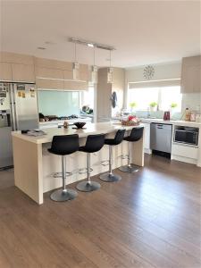 a kitchen with a island with bar stools at Sylvia Park House in Auckland