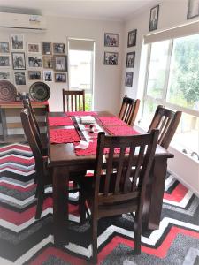 a dining room with a wooden table and chairs at Sylvia Park House in Auckland