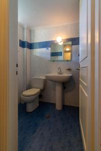 bagno con lavandino, servizi igienici e specchio di Averto a Città di Lefkada