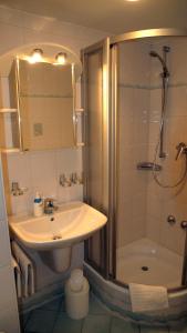ein Bad mit einem Waschbecken und einer Dusche in der Unterkunft Gaestehaus Seliger in Meersburg
