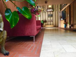 un sofá rojo en el vestíbulo con una planta en The Pemberton Hotel, en Pemberton