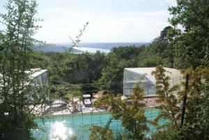 uma vista para uma piscina com árvores em Le Bosquet em Aiguines