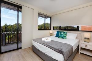 Global Backpackers Cairns في كيرنز: غرفة نوم بسرير ونافذة كبيرة