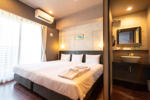 a bedroom with a bed with a sink and a mirror at NAHA-WEST INN in Naha