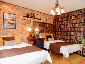 two beds in a room with large bookshelves at West Taisho in Osaka