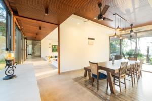a dining room with a table and chairs at ama Stays & Trails Sherlys Ente Kumbalanghi, Kochi in Tekkumuri
