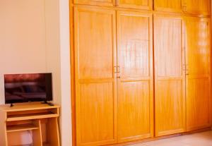 a room with wooden cabinets and a tv at Charis Home Services in Accra