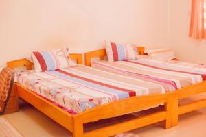Charis Home Services في آكرا: سريرين يجلسون بجانب بعض في غرفة