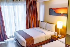 a hotel room with a bed and a lamp at Crown Regency Beach Resort in Boracay