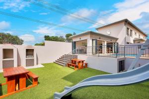 a yard with a slide and a house at Innov8 Spaces in Johannesburg