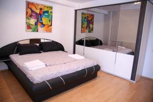 ママイアにあるC&Y Apartments Metropolのベッドルーム(ベッド1台、大きな鏡付)