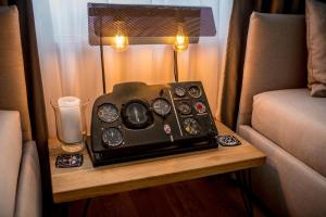 クルジュ・ナポカにあるThe Aviator Apartment - Jacuzzi & Panoramic Viewのソファの横のテーブル上のラジオ
