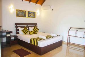 una camera da letto con un letto con cuscini gialli e neri di Sigiriya Nature Resort a Sigiriya