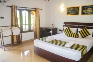 a bedroom with a bed and a desk in it at Sigiriya Nature Resort in Sigiriya