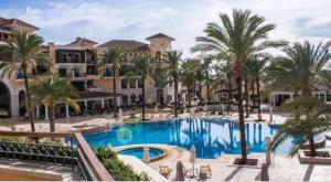 a resort with a large swimming pool with palm trees at Mar Menor Golf Villa - Frontline Detached - Heated Pool in Torre-Pacheco