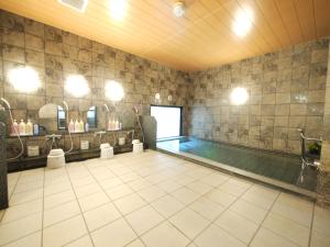 a swimming pool in a room with a swimming pool at Hotel Route-Inn Satsumasendai in Satsumasendai