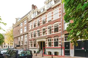 アムステルダムにあるAmsterdam Appartment in the centre of Amsterdamの大きなレンガ造りの建物の前に停められた車